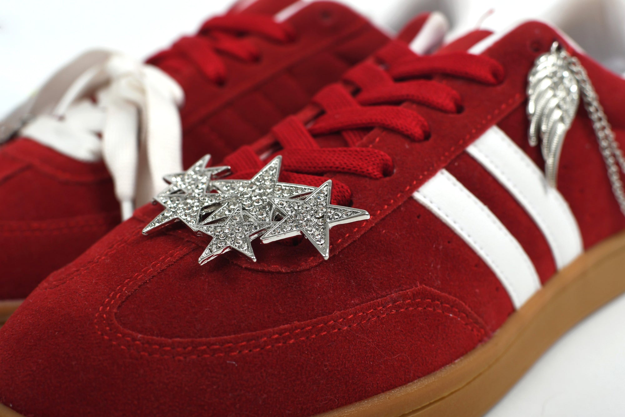 Red sneakers with star-shaped embellishments on a white background
